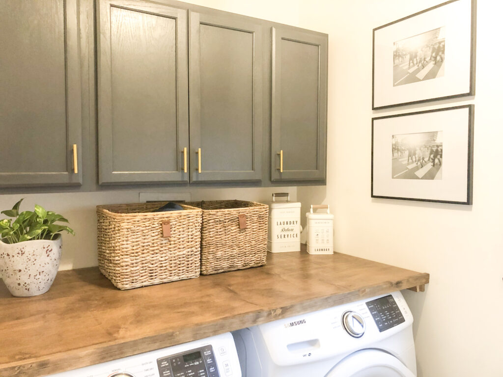 modern farmhouse laundry room with gray cabinets and wooden countertop

