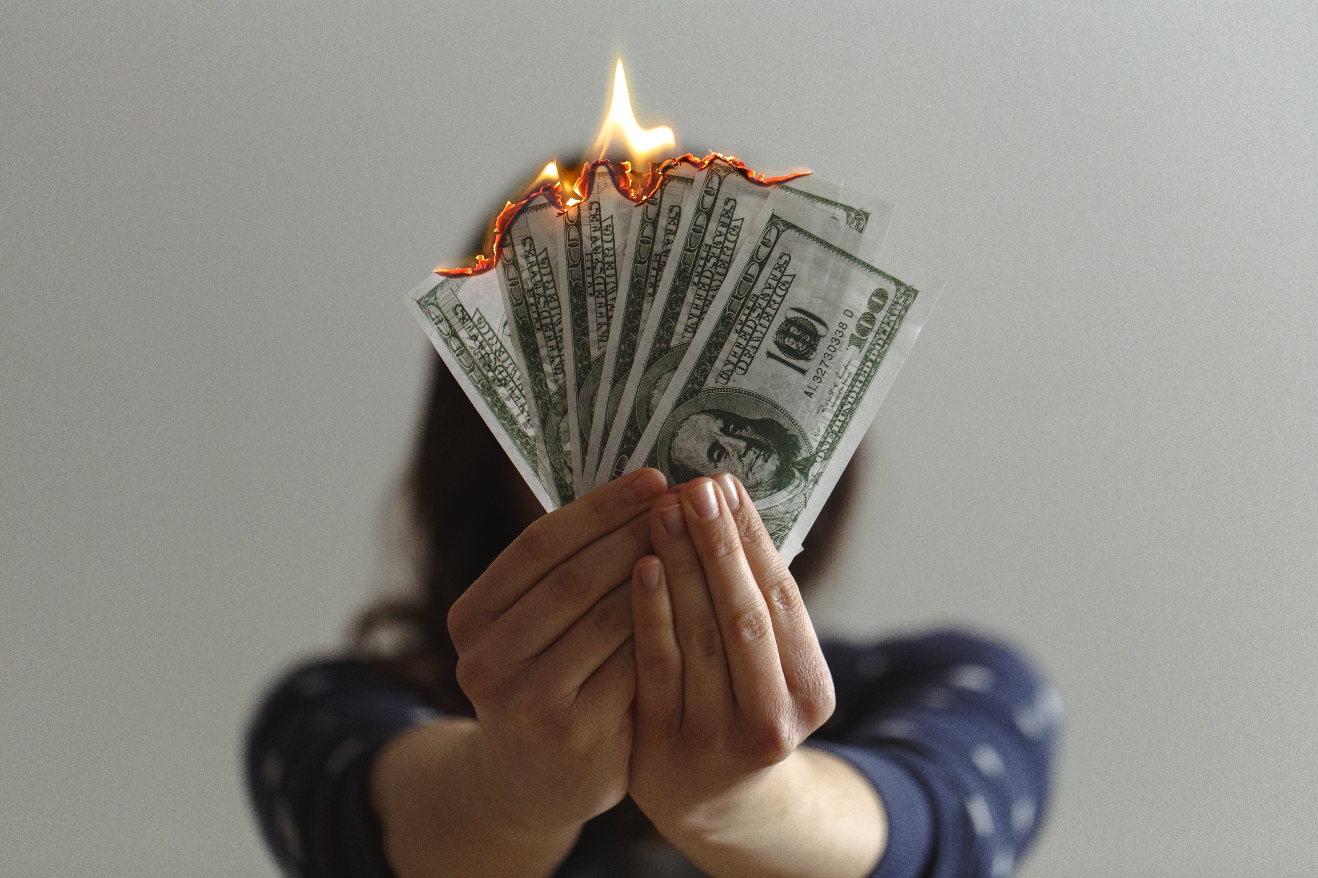 hands holding money on fire